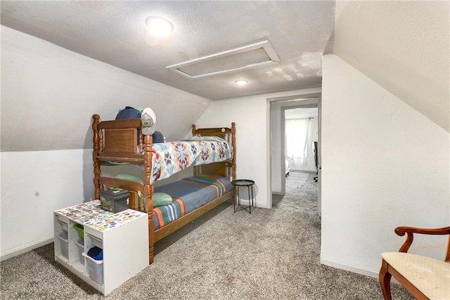 carpeted bedroom featuring attic access, lofted ceiling, a textured ceiling, and baseboards