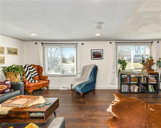 sitting room with a textured ceiling, wood finished floors, visible vents, and baseboards