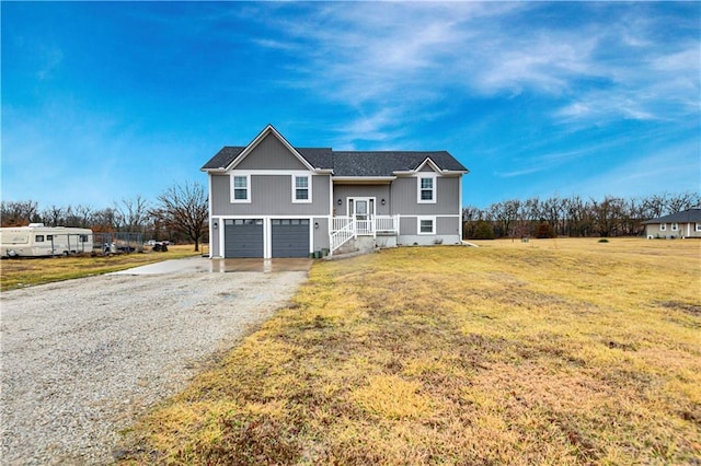 view of front of property featuring a front yard, driveway, and an attached garage