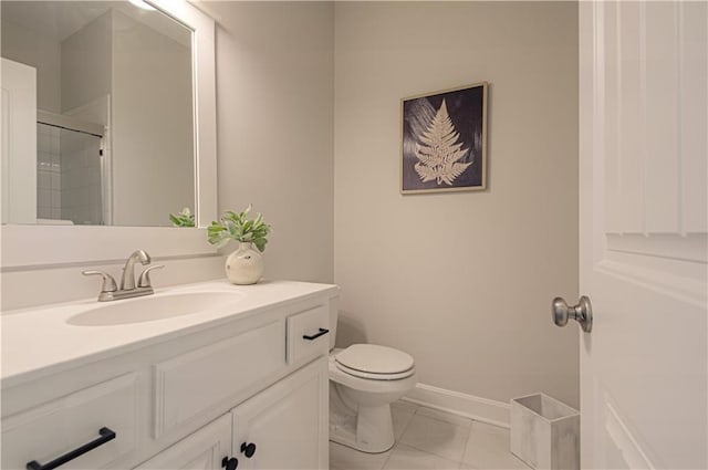 bathroom featuring a shower with shower door, toilet, vanity, baseboards, and tile patterned floors