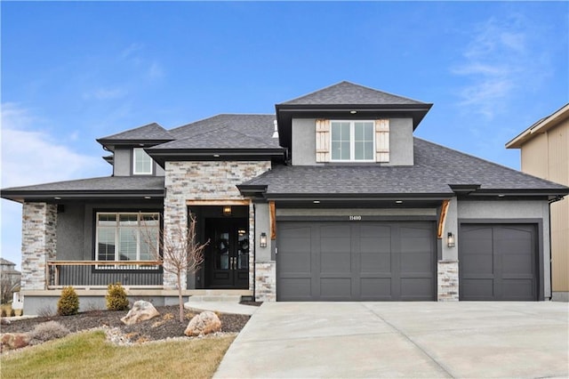 prairie-style home with stone siding, a porch, concrete driveway, and stucco siding