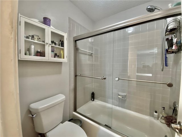 bathroom with enclosed tub / shower combo, toilet, and a textured ceiling