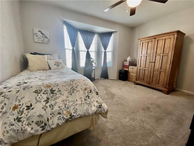 bedroom featuring light carpet and a ceiling fan