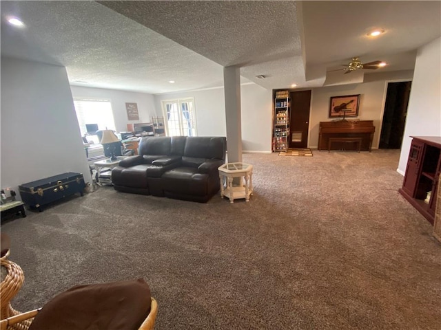 living area with a textured ceiling, recessed lighting, carpet floors, a fireplace, and ceiling fan