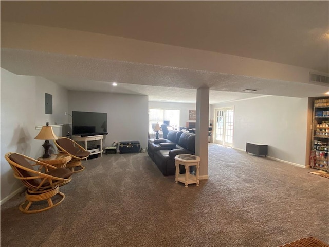 living area featuring visible vents, electric panel, a textured ceiling, carpet floors, and baseboards