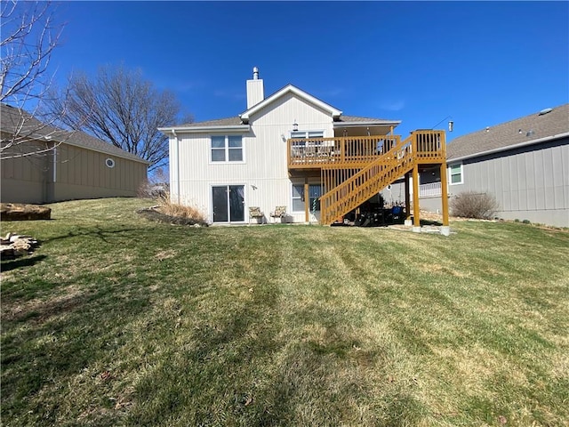 rear view of property featuring a yard, a chimney, a deck, and stairs