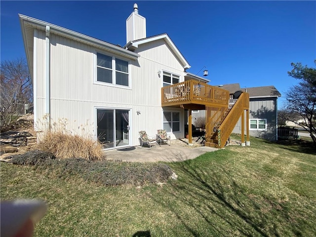 rear view of house featuring stairway, a chimney, a deck, a yard, and a patio