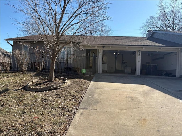 view of front of property featuring a garage, concrete driveway, and fence