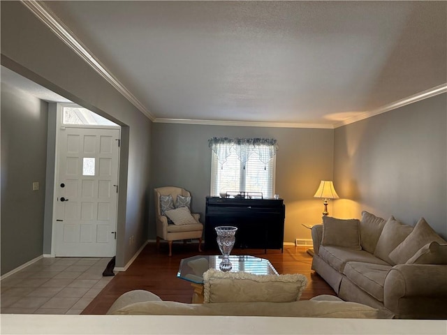 living room featuring ornamental molding, tile patterned flooring, and baseboards