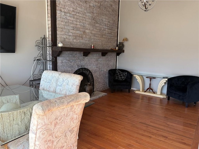 sitting room featuring a brick fireplace and wood finished floors