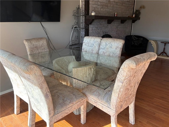 dining area featuring a fireplace and wood finished floors