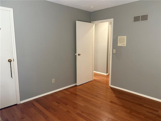 unfurnished bedroom featuring baseboards, visible vents, and wood finished floors