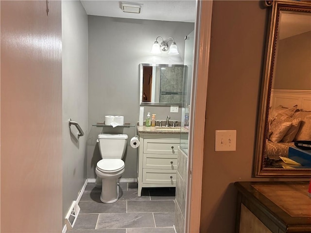 bathroom with visible vents, vanity, toilet, and baseboards