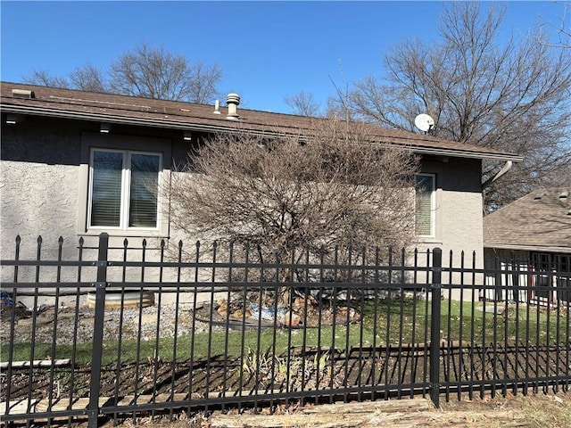 exterior space with a fenced front yard and stucco siding