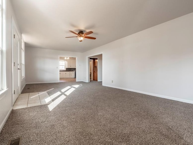 unfurnished living room featuring light carpet, ceiling fan, visible vents, and baseboards