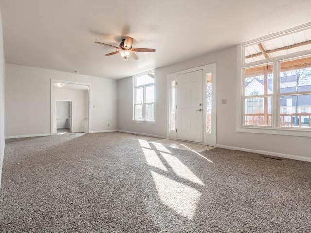 carpeted foyer with baseboards and a ceiling fan