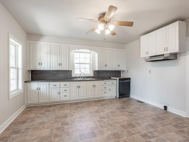 kitchen with under cabinet range hood, black dishwasher, baseboards, and a sink