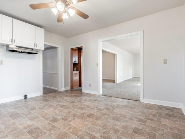 interior space with stone finish floor, ceiling fan, and baseboards