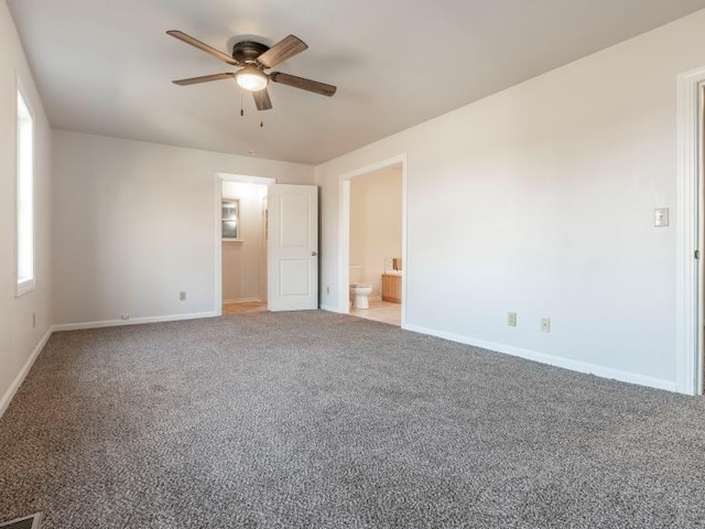 carpeted spare room with a ceiling fan and baseboards