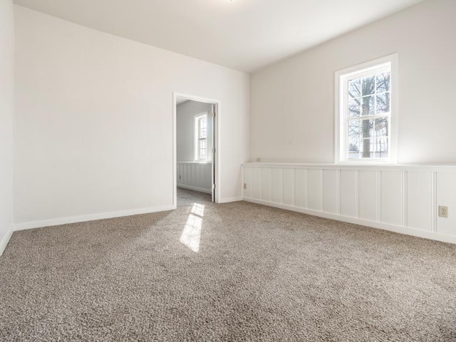 carpeted empty room featuring baseboards