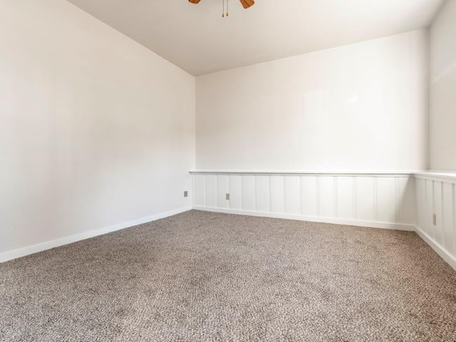 carpeted empty room with baseboards and a ceiling fan