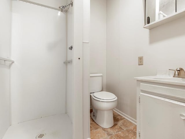 bathroom featuring vanity, a shower stall, and toilet