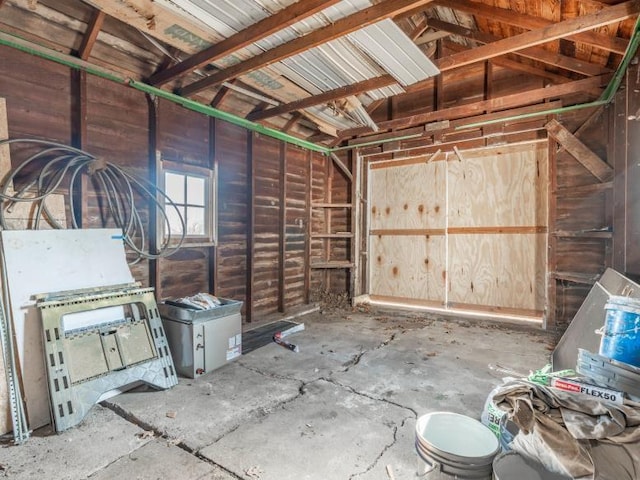 misc room featuring lofted ceiling and a garage