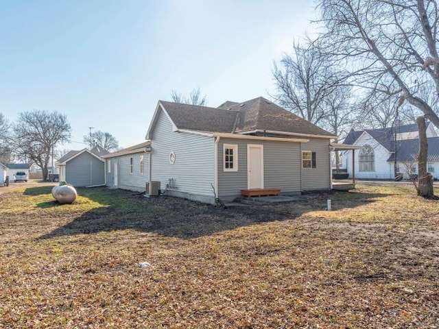 back of property with entry steps, a yard, and central air condition unit