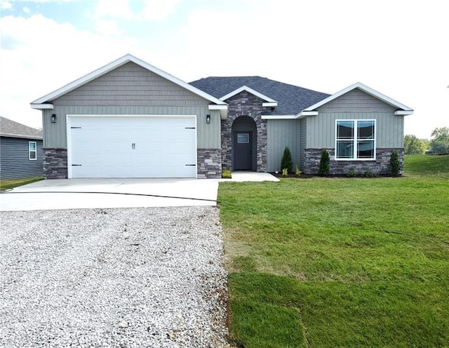 view of front of property featuring driveway, a front lawn, an attached garage, and stone siding