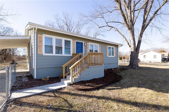 view of front of house featuring fence and an attached carport