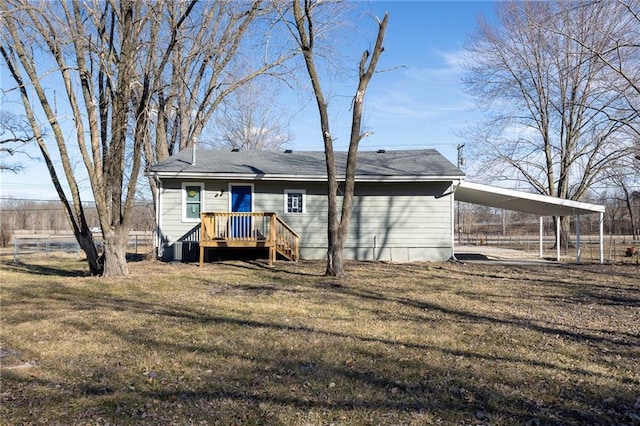 rear view of property with a deck, a carport, and a yard