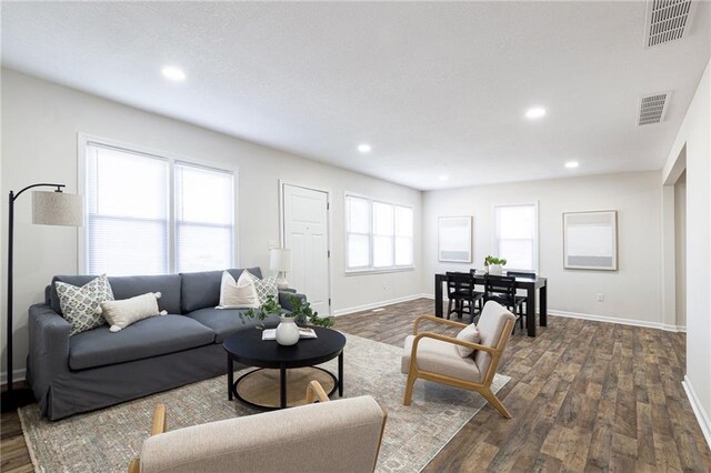 living area with visible vents and dark wood finished floors