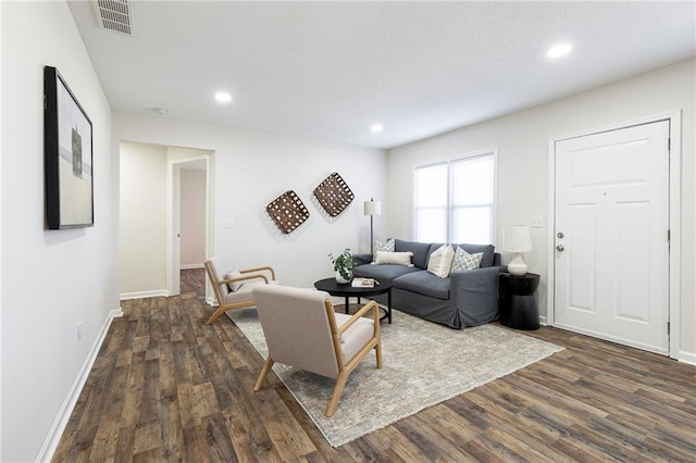 living area with baseboards, dark wood-style flooring, visible vents, and recessed lighting