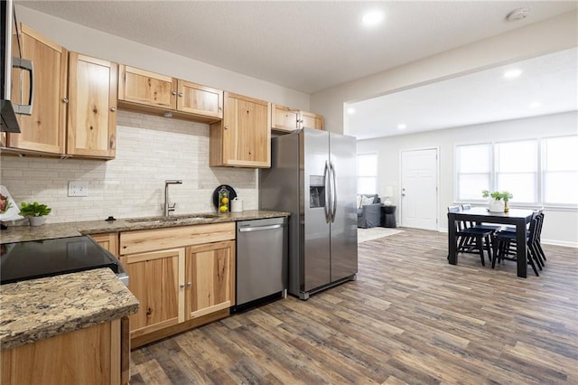 kitchen with light brown cabinets, appliances with stainless steel finishes, dark wood-type flooring, and a sink