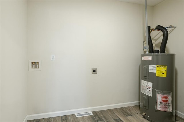 utility room featuring water heater and visible vents