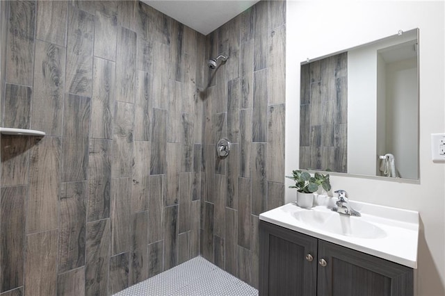 bathroom featuring tiled shower and vanity