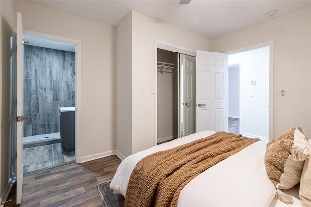 bedroom with dark wood-style floors, a closet, ensuite bath, and baseboards