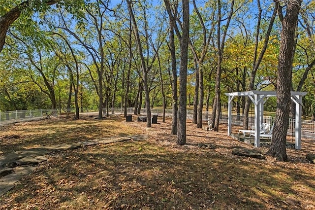 view of yard featuring fence and a pergola