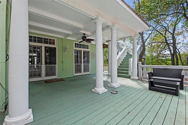 wooden terrace with a ceiling fan and stairway