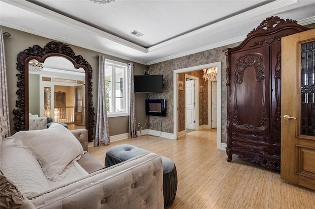 living room with light wood finished floors, baseboards, visible vents, a tray ceiling, and a fireplace