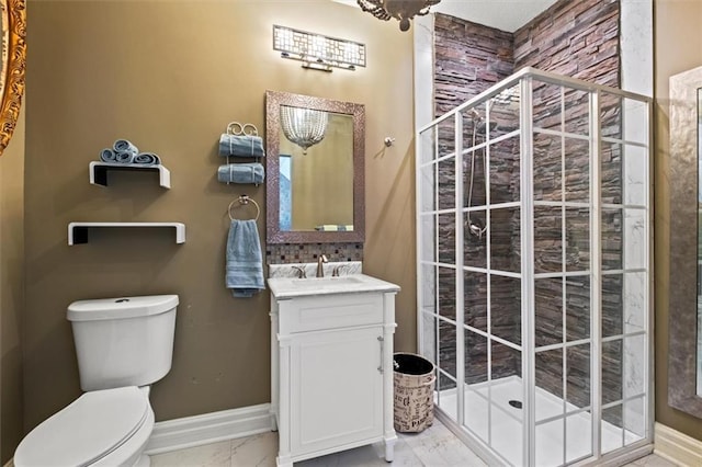 bathroom with baseboards, toilet, marble finish floor, a tile shower, and vanity