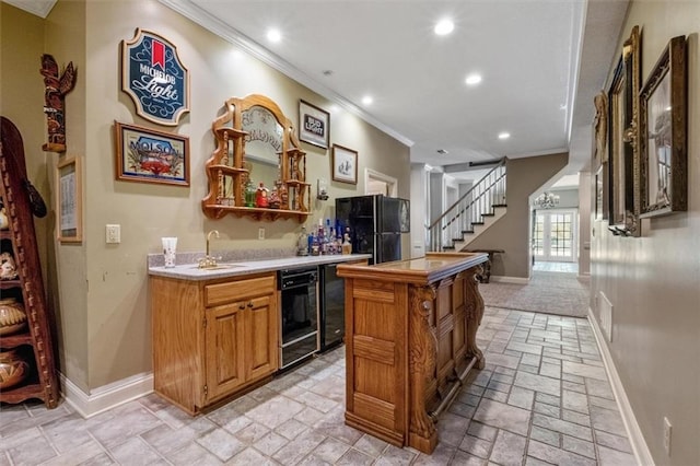 bar with indoor wet bar, crown molding, stone tile flooring, black appliances, and stairs