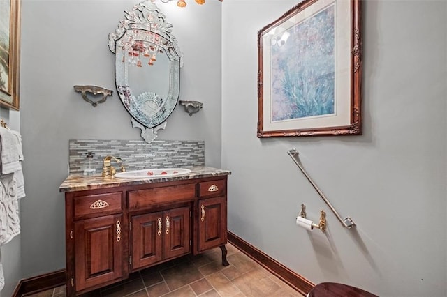 bathroom featuring backsplash, vanity, and baseboards