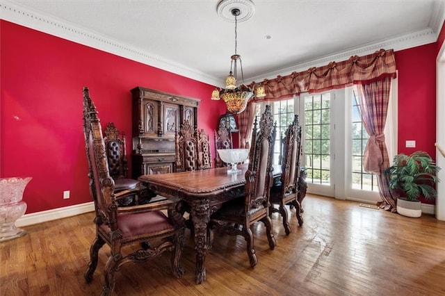 dining area featuring crown molding, baseboards, and wood finished floors