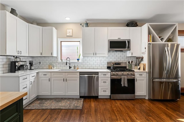 kitchen featuring a sink, stainless steel appliances, decorative backsplash, and dark wood-style flooring