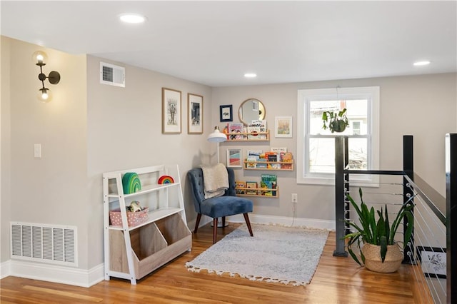 sitting room with recessed lighting, wood finished floors, visible vents, and baseboards