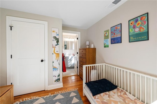 bedroom with wood finished floors and visible vents