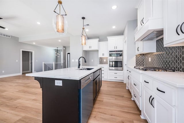 kitchen featuring stainless steel appliances, visible vents, a sink, and light wood-style flooring