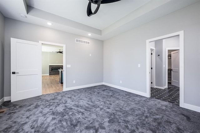 unfurnished bedroom with carpet, recessed lighting, visible vents, a tiled fireplace, and baseboards