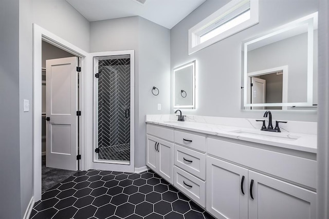 full bathroom with double vanity, a stall shower, and a sink